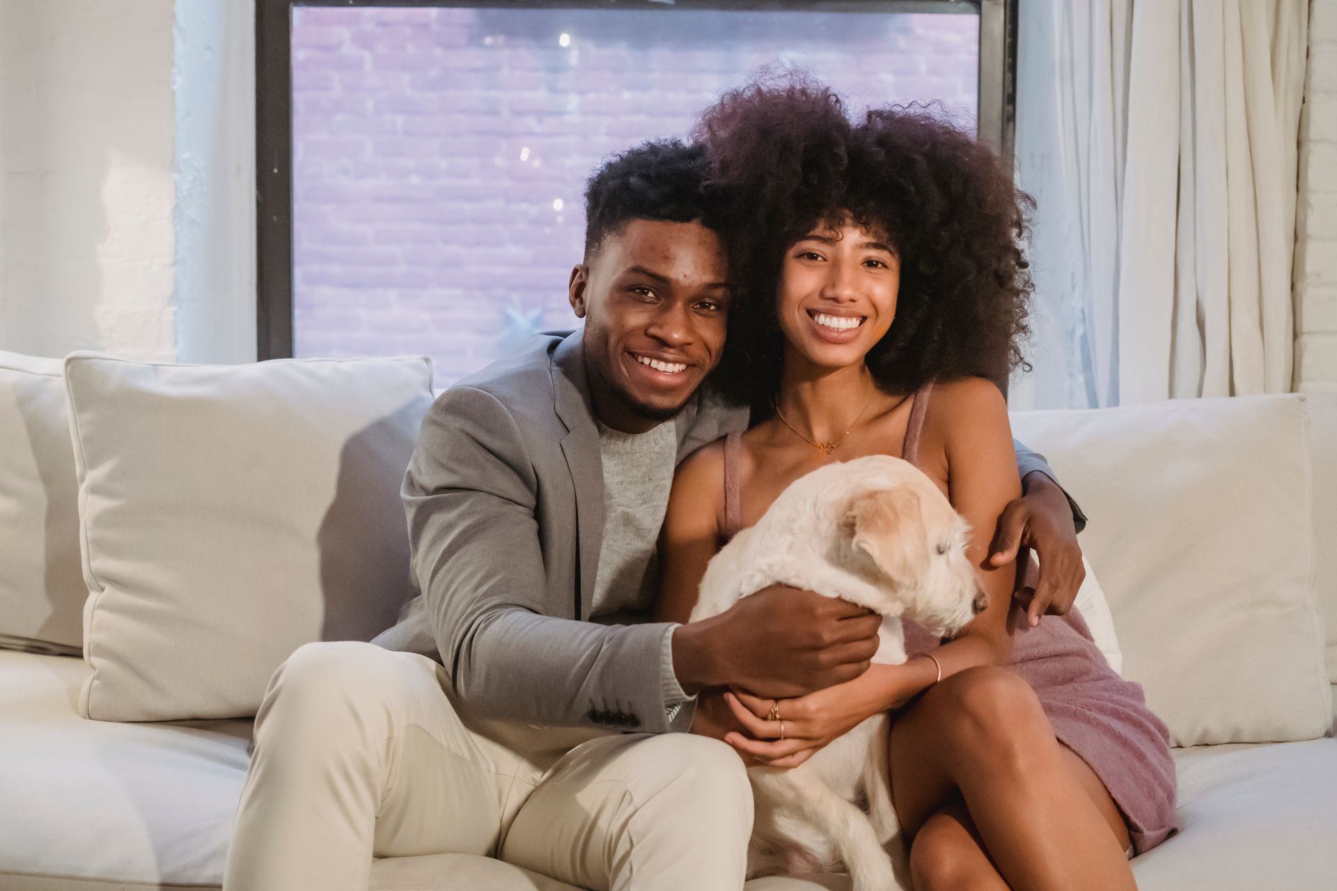 Casal feliz no sofá com seu cachorro